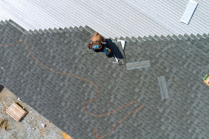 arial view of roofers installing new shingles on home